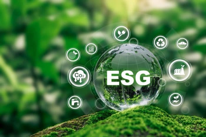 An ESG glowing sphere with sustainability icons over moss